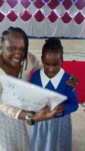 A student from Kilimani Primary School receiving a reward.